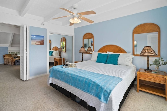 bedroom with light carpet, a closet, ceiling fan, and vaulted ceiling with beams