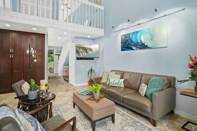 living room with light tile flooring and a high ceiling