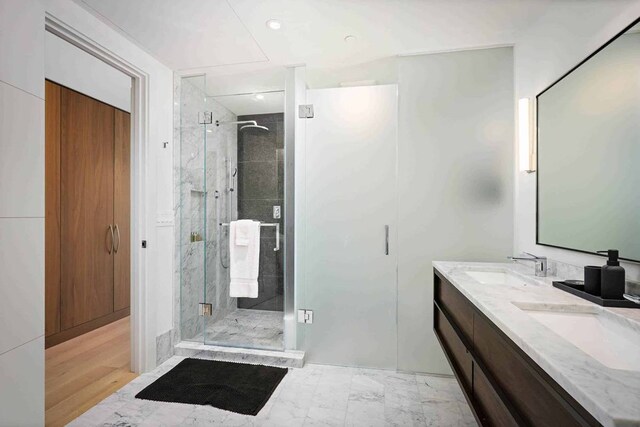 bathroom featuring an enclosed shower, double vanity, and tile floors