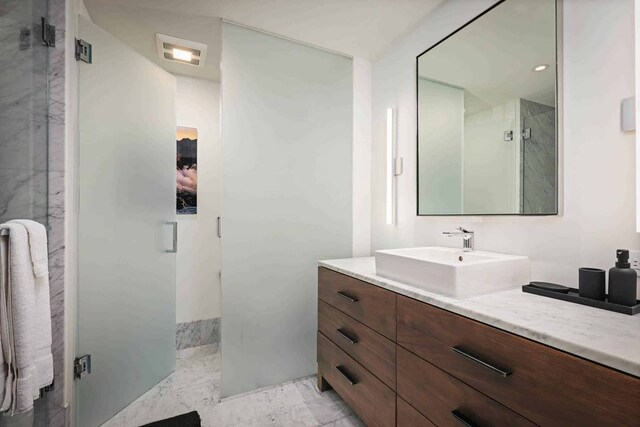 bathroom featuring vanity, tiled shower, and tile flooring