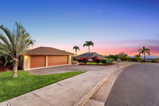 single story home with a garage and a lawn