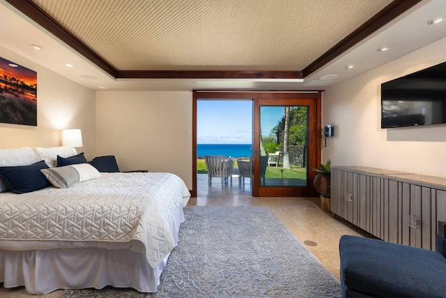 bedroom featuring a water view, a raised ceiling, and access to outside