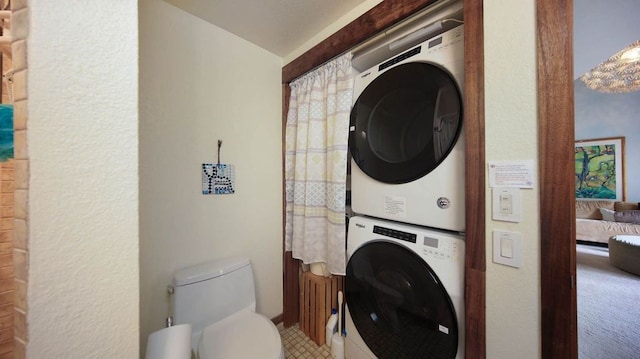 clothes washing area featuring laundry area and stacked washing maching and dryer