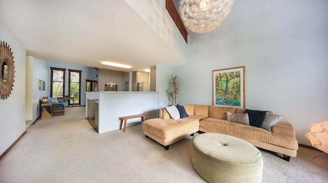 living room with baseboards, light colored carpet, and an inviting chandelier