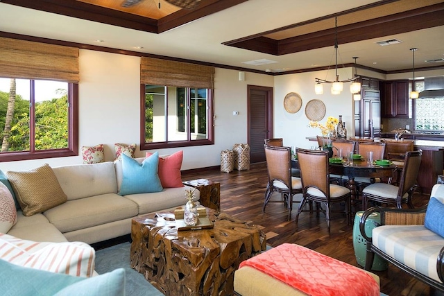 living room with crown molding, dark hardwood / wood-style floors, and a tray ceiling