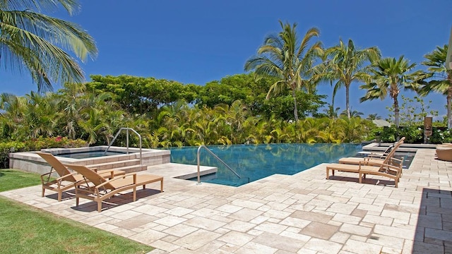 view of pool with a patio area and an in ground hot tub