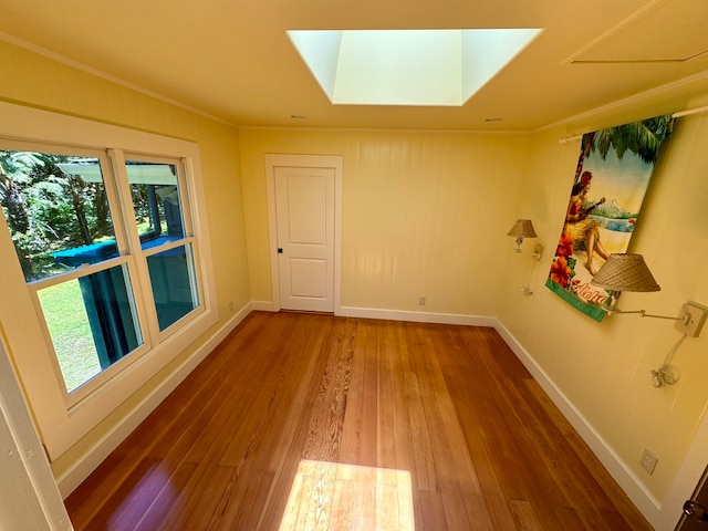 unfurnished room featuring wood-type flooring and a skylight