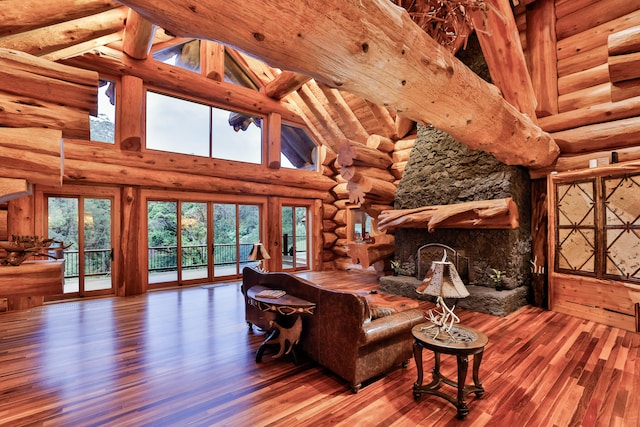 living room with high vaulted ceiling, a stone fireplace, wood finished floors, beamed ceiling, and rustic walls