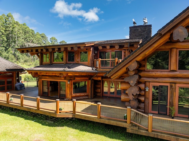 back of house featuring french doors, a chimney, log siding, and a wooden deck