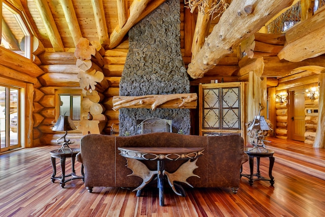 living room featuring high vaulted ceiling, beamed ceiling, a fireplace, and wood-type flooring