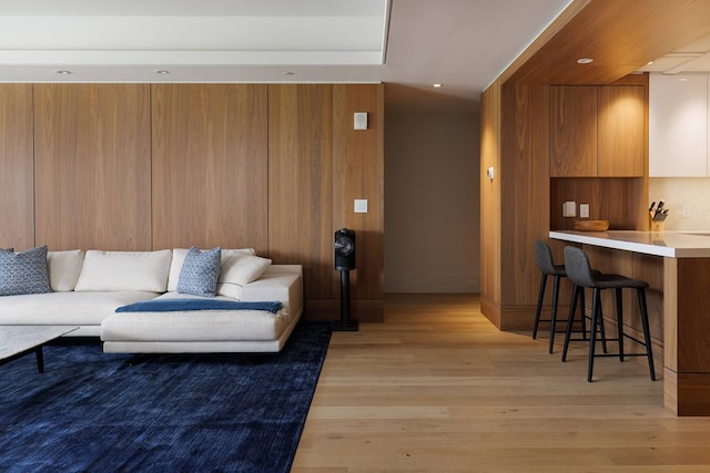 living room with light hardwood / wood-style flooring and bar