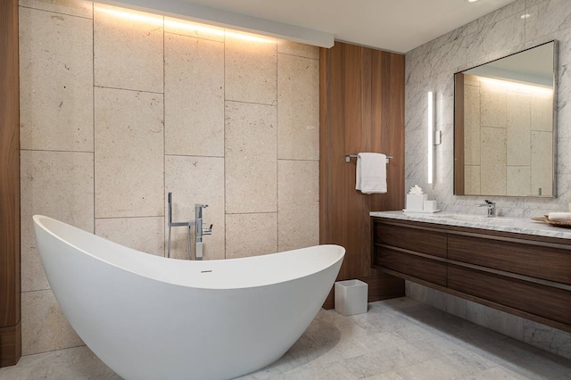 bathroom with tile walls, tile floors, vanity, and a bathtub