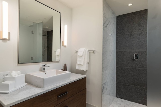 bathroom featuring a tile shower and vanity