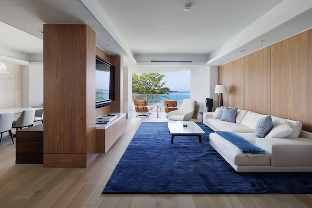 living room featuring light hardwood / wood-style flooring and a water view