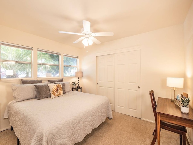 carpeted bedroom with ceiling fan and a closet