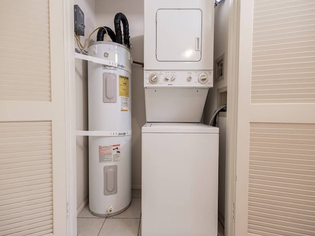 laundry area featuring water heater, stacked washer / dryer, and light tile patterned floors