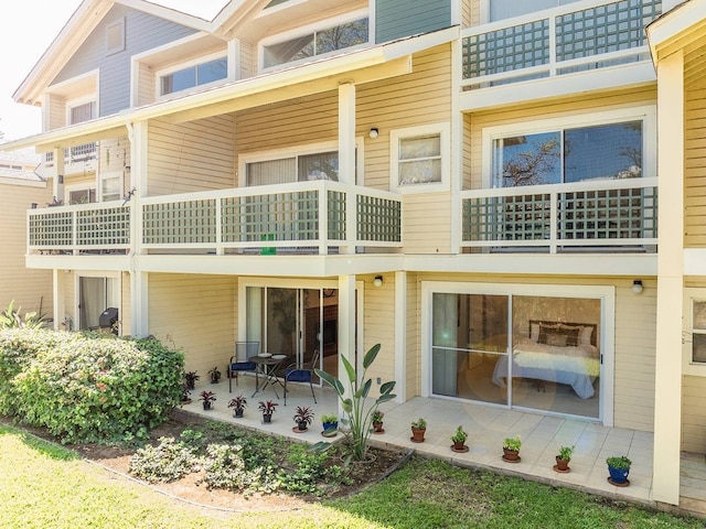 back of property featuring a balcony and a patio area