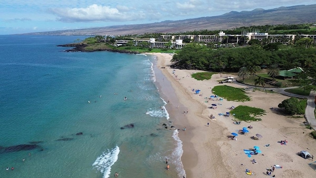 birds eye view of property with a water view and a beach view