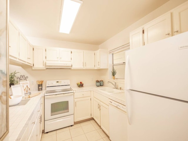 kitchen featuring light tile patterned flooring, white cabinets, white appliances, tile counters, and sink