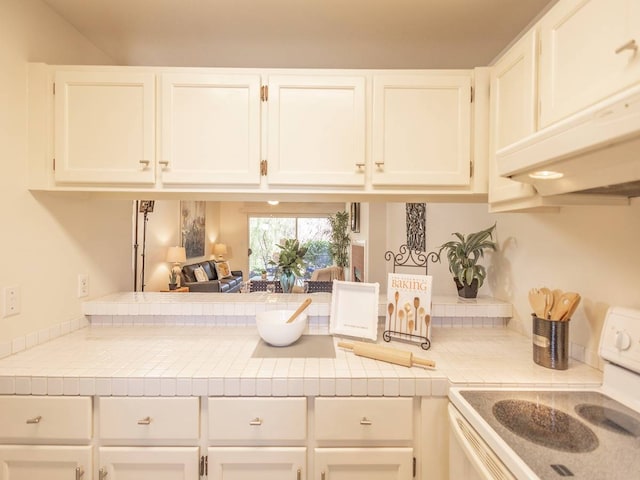 kitchen with white cabinetry, tile countertops, electric range, and ventilation hood