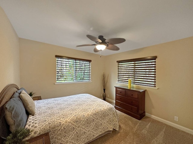 carpeted bedroom with ceiling fan and multiple windows