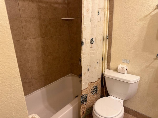 bathroom featuring toilet and tiled shower / bath