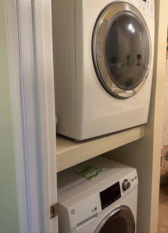 clothes washing area with stacked washer / dryer