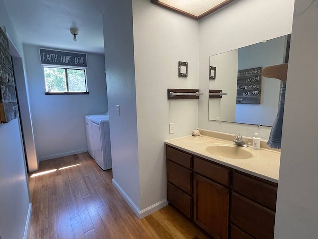 bathroom with washer and dryer, vanity, and hardwood / wood-style flooring