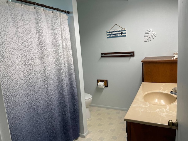 bathroom with tile floors, toilet, and vanity