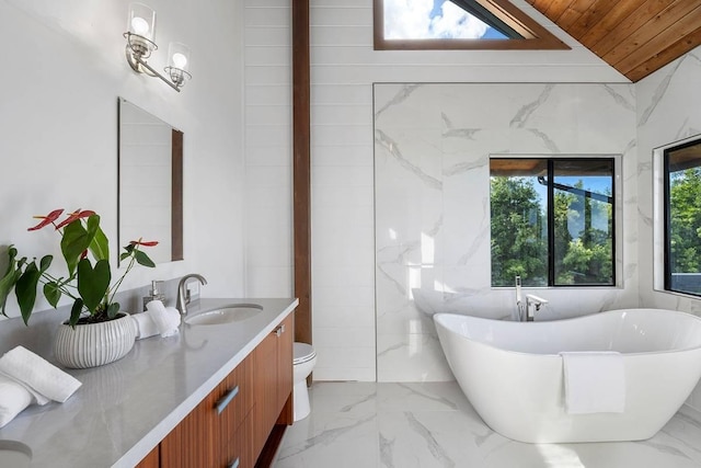 full bathroom with marble finish floor, a soaking tub, wood ceiling, vaulted ceiling, and vanity