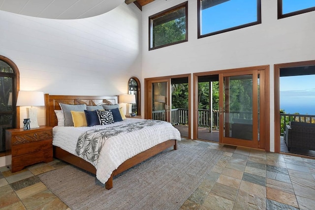 bedroom with stone tile floors and access to exterior