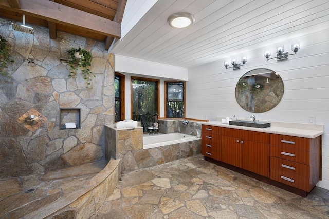 full bath with tiled shower, wood ceiling, stone finish flooring, vanity, and a bath