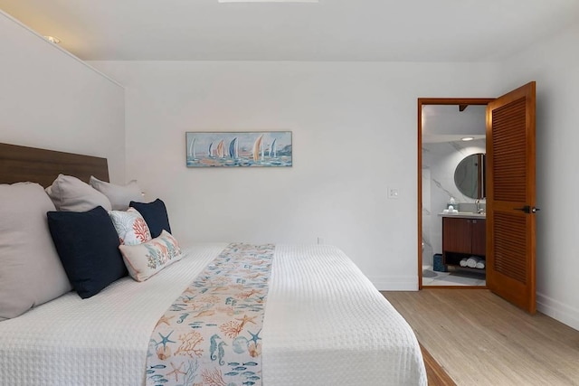 bedroom with baseboards and wood finished floors