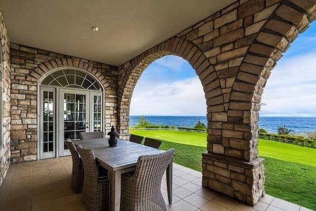 view of patio with french doors and a water view