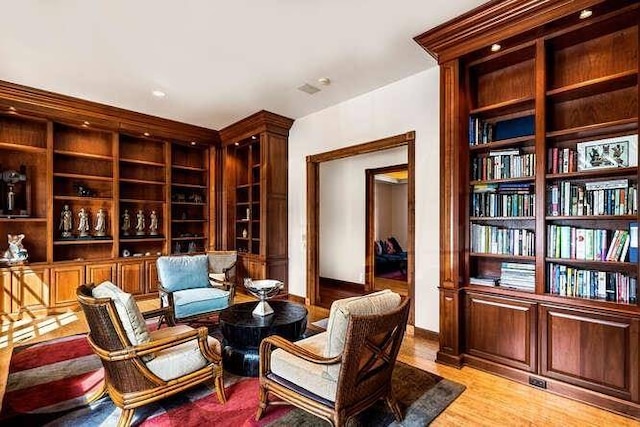 living area featuring built in features and light hardwood / wood-style floors