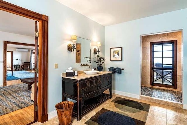 bathroom featuring tile floors, an AC wall unit, and vanity