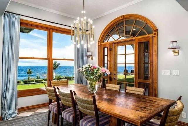 dining area featuring french doors, a water view, ornamental molding, and a chandelier