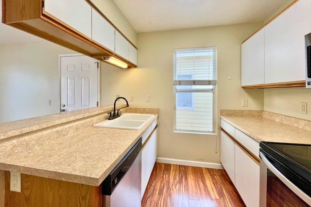 kitchen with kitchen peninsula, stainless steel appliances, hardwood / wood-style flooring, white cabinetry, and sink