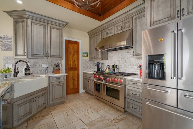 kitchen featuring backsplash, light tile flooring, high quality appliances, and sink