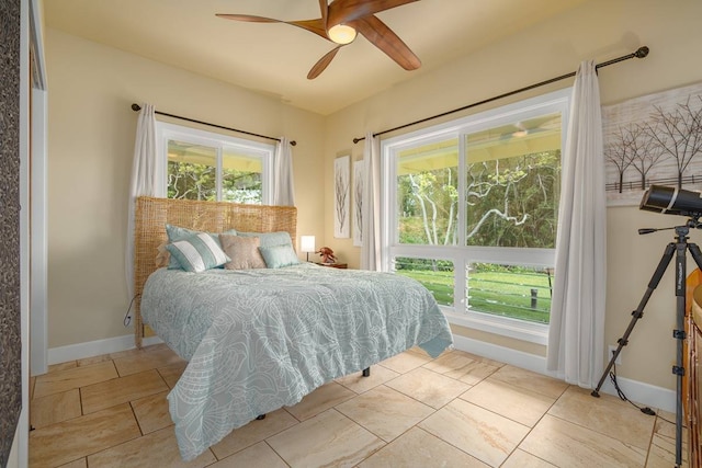 bedroom featuring ceiling fan, light tile floors, and multiple windows