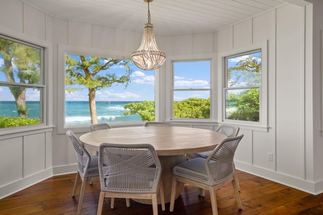 sunroom featuring a water view and a notable chandelier