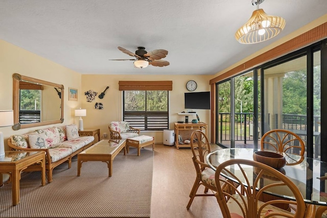 living room featuring ceiling fan, a wealth of natural light, and light wood-type flooring