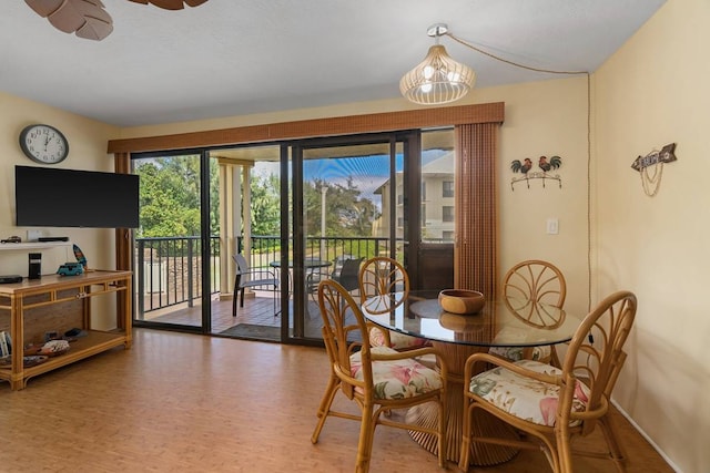 dining space with hardwood / wood-style floors and ceiling fan with notable chandelier