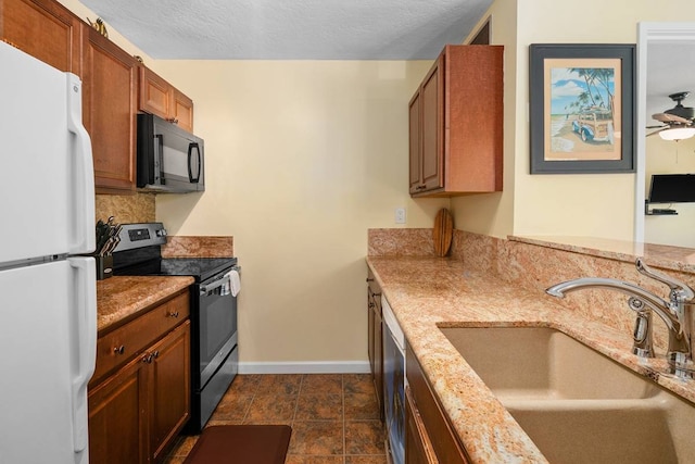 kitchen with white refrigerator, electric range, ceiling fan, dark tile flooring, and sink