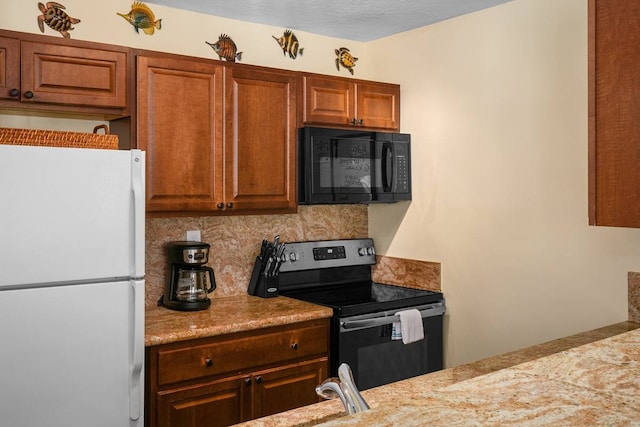 kitchen with backsplash, white refrigerator, and stainless steel range with electric stovetop