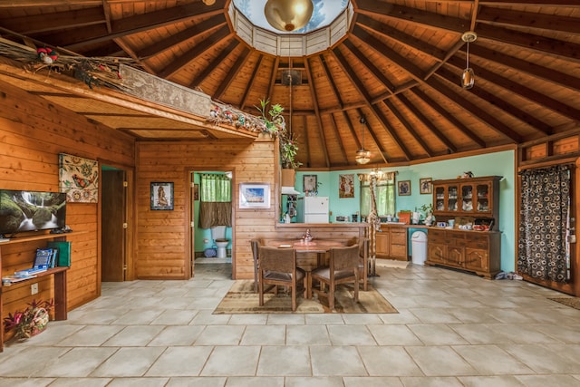 tiled dining room with wooden ceiling, wooden walls, and a high ceiling