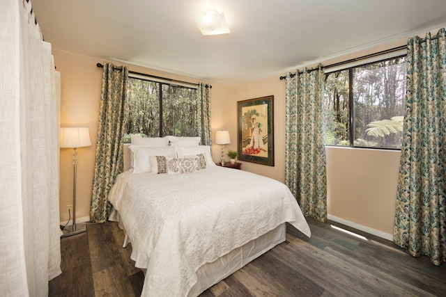 bedroom with dark hardwood / wood-style flooring