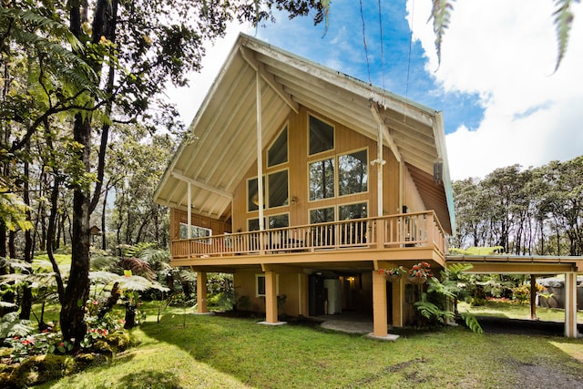 rear view of house with a lawn and a wooden deck