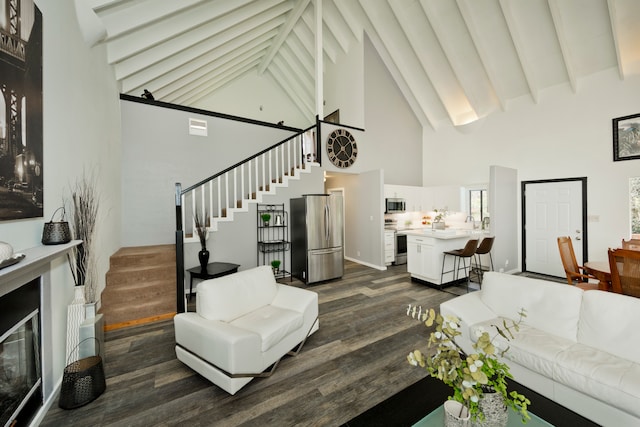 living room featuring beamed ceiling, high vaulted ceiling, and dark wood-type flooring