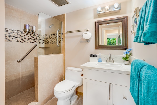 bathroom featuring toilet, oversized vanity, and a tile shower